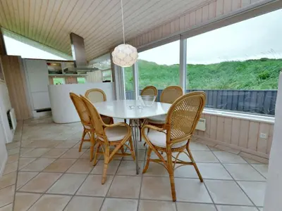 a dining room with a white table and chairs at Holiday Home Hadar - 100m from the sea by Interhome in Saltum
