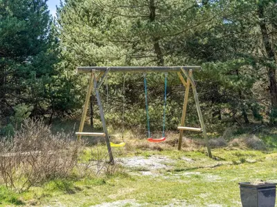 a swing in a field with three frisbees at Holiday Home Antoinetta - 900m from the sea by Interhome in Saltum