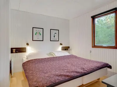 a bedroom with a bed with a purple comforter at Holiday Home Antoinetta - 900m from the sea by Interhome in Saltum