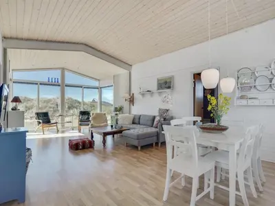 a living room with a white table and chairs at Holiday Home Felis - 200m from the sea by Interhome in Saltum