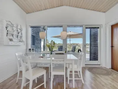 a white dining room with a white table and chairs at Holiday Home Felis - 200m from the sea by Interhome in Saltum
