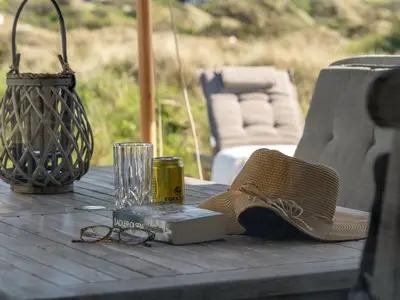 a picnic table with a basket and glasses and a book at Holiday Home Felis - 200m from the sea by Interhome in Saltum