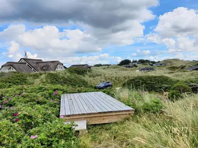 a wooden platform in the middle of a field with flowers at Holiday Home Felis - 200m from the sea by Interhome in Saltum