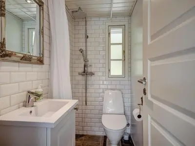 a bathroom with a toilet and a sink and a mirror at Holiday Home Maunu - 1-2km from the sea by Interhome in Saltum