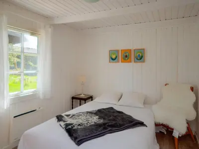 a white bedroom with a bed and a window at Holiday Home Maunu - 1-2km from the sea by Interhome in Saltum