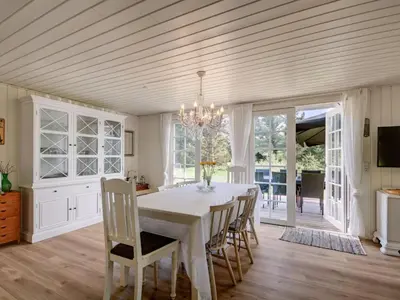 a dining room with a white table and chairs at Holiday Home Maunu - 1-2km from the sea by Interhome in Saltum