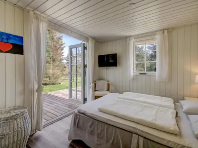 a bedroom with a bed and a sliding glass door at Holiday Home Maunu - 1-2km from the sea by Interhome in Saltum