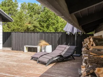 a group of lounge chairs on a deck at Holiday Home Kadife - 750m from the sea by Interhome in Saltum