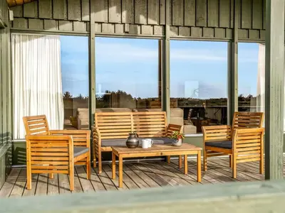 a patio with a table and chairs and windows at Holiday Home Fransine - 480m from the sea by Interhome in Saltum