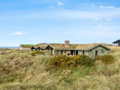 a house on top of a grassy hill at Holiday Home Fransine - 480m from the sea by Interhome in Saltum