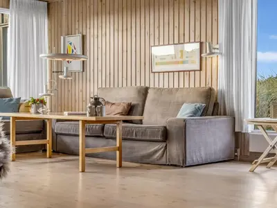 a living room with a couch and a table at Holiday Home Fransine - 480m from the sea by Interhome in Saltum