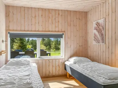 two beds in a room with a window at Holiday Home Nayati - 2km from the sea by Interhome in Saltum