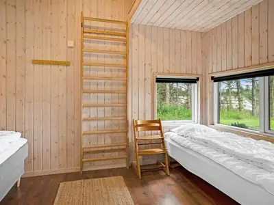 a room with a bed and a chair in it at Holiday Home Nayati - 2km from the sea by Interhome in Saltum