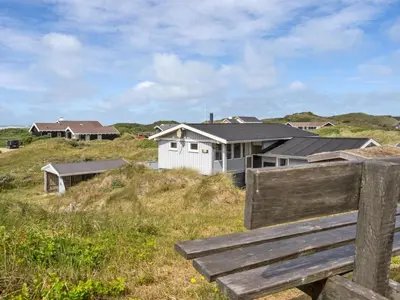 a bench sitting on top of a hill with houses at Holiday Home Kulle - 200m from the sea by Interhome in Saltum