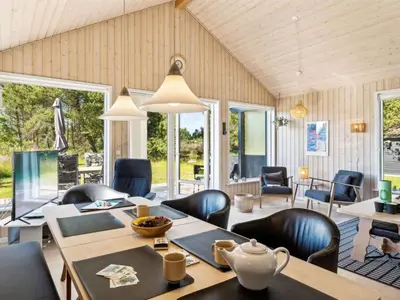 a dining room with a table and chairs at Holiday Home Swen - 1-3km from the sea by Interhome in Saltum