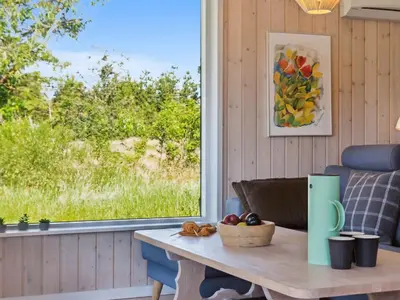 a table with a bowl of fruit on top of it next to a window at Holiday Home Swen - 1-3km from the sea by Interhome in Saltum