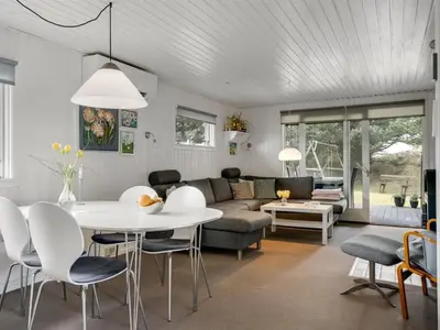 a living room with a white table and chairs at Holiday Home Gerwer - 700m from the sea by Interhome in Saltum