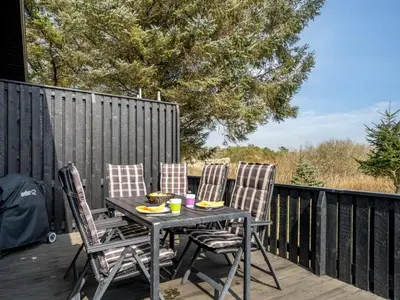 a table and two chairs on a deck at Holiday Home Gerwer - 700m from the sea by Interhome in Saltum