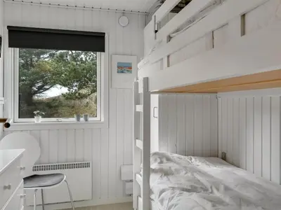 a white bedroom with a bunk bed and a window at Holiday Home Gerwer - 700m from the sea by Interhome in Saltum