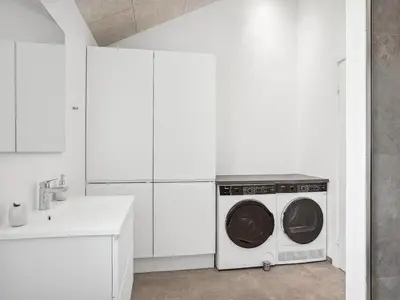 a white kitchen with a washing machine in it at Holiday Home Fredrika - 1-5km from the sea by Interhome in Saltum