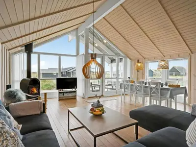 a living room with a couch and a table at Holiday Home Sochyeta - 150m from the sea by Interhome in Harboør