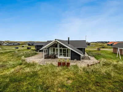 a house sitting on top of a grass field at Holiday Home Sochyeta - 150m from the sea by Interhome in Harboør