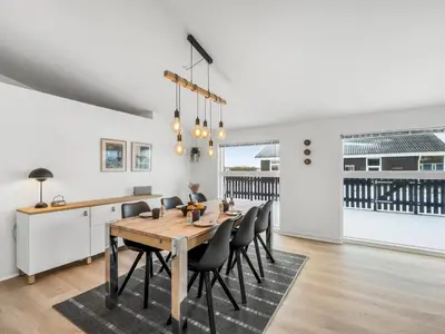 a dining room with a wooden table and chairs at Holiday Home Damaskin - 300m from the sea by Interhome in Harboør