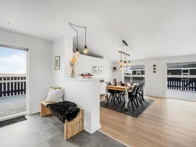 a kitchen and dining room with a table and chairs at Holiday Home Damaskin - 300m from the sea by Interhome in Harboør