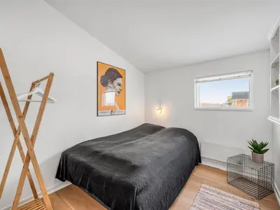 a bedroom with a large bed and a window at Holiday Home Damaskin - 300m from the sea by Interhome in Harboør