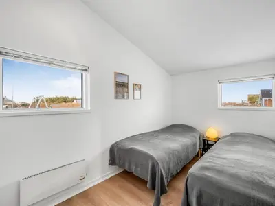 two beds in a white room with a window at Holiday Home Damaskin - 300m from the sea by Interhome in Harboør