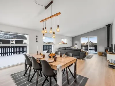 a dining room and living room with a table and chairs at Holiday Home Damaskin - 300m from the sea by Interhome in Harboør