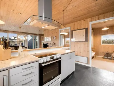 a kitchen with white cabinets and a stove top oven at Holiday Home Odmar - 300m from the sea by Interhome in Harboør