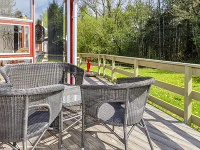 two chairs and a table on a wooden deck at 4 person holiday home in Højslev-By Traum in Højslev