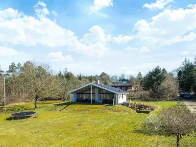 a small house on a grassy field in front of a house at 7 person holiday home in Skals-By Traum in Skals