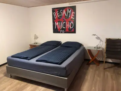 a bedroom with a bed and a sign on the wall at La Ola in Hanstholm