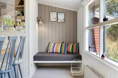 a small porch with a bench and a window at Cozy Holiday Home in Lovely Surroundings in Sønder Vorupør