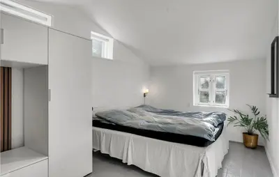 a bedroom with a bed in a white room at Amazing Home In Pandrup in Pandrup