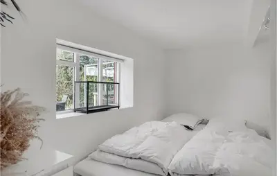 a bed in a white room with a window at Amazing Home In Pandrup in Pandrup