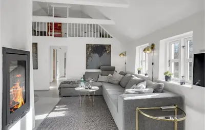 a living room with a couch and a fireplace at Amazing Home In Pandrup in Pandrup