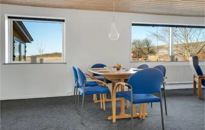 a dining room with a table and blue chairs at 3 Bedroom Awesome Home In Thisted in Thisted