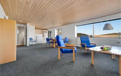 a waiting room with blue chairs and a table at 3 Bedroom Awesome Home In Thisted in Thisted