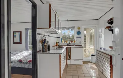 a kitchen with white cabinets and a bed in a room at Awesome Home In Fjerritslev With Wifi in Fjerritslev