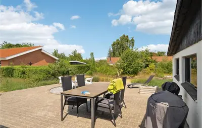 a patio with a table and chairs on a patio at Cozy Home In Nykøbing M With Wifi in Refshammer