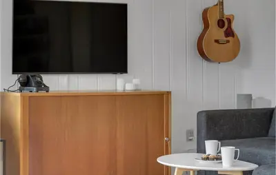 a flat screen tv sitting on top of a entertainment center at Cozy Home In Nykøbing M With Wifi in Refshammer