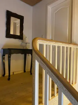a stairway with a table and a mirror on the wall at 200 m til havet - fri adgang til svømmehal in Thyborøn