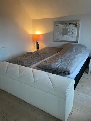 a large white bed in a room with at 200 m til havet - fri adgang til svømmehal in Thyborøn