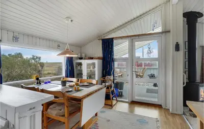 a kitchen with a table and a large window at 3 Bedroom Lovely Home In Lemvig in Lemvig