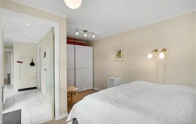 a bedroom with a white bed and a bathroom at Nice Home In Fur With Sauna in Furland
