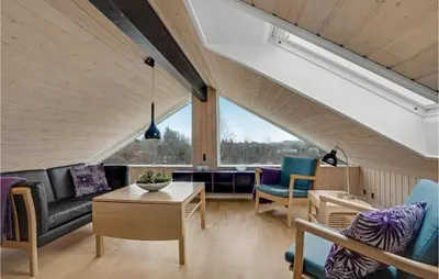 an attic living room with a couch and chairs at Nice Home In Fur With Sauna in Furland
