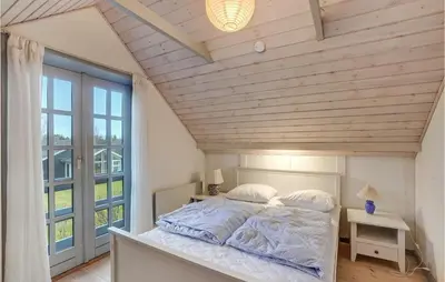 a bedroom with a large bed with a large window at 3 Bedroom Gorgeous Home In Højslev in Højslev